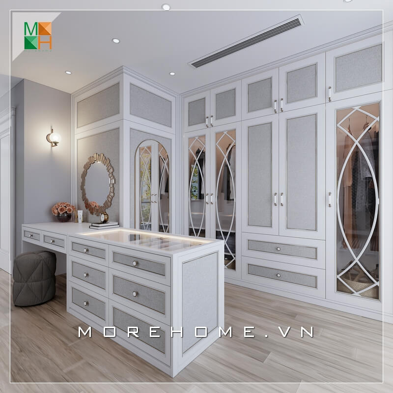 Mẫu phòng thay đồ đẹp cho biệt thự, chung cư cao cấp mang phong cách tân cổ điển, sử dụng gam màu trắng xám làm chủ đạo với hệ tủ âm tường kịch trần và đảo phụ kiện kết hợp bàn trang điểm, giúp không gian thử đồ của gia chủ trở nên gọn gàng nhưng cũng không kém phần sang trọng, đẳng cấp Mẫu nội thất biệt thự tân cổ điển
